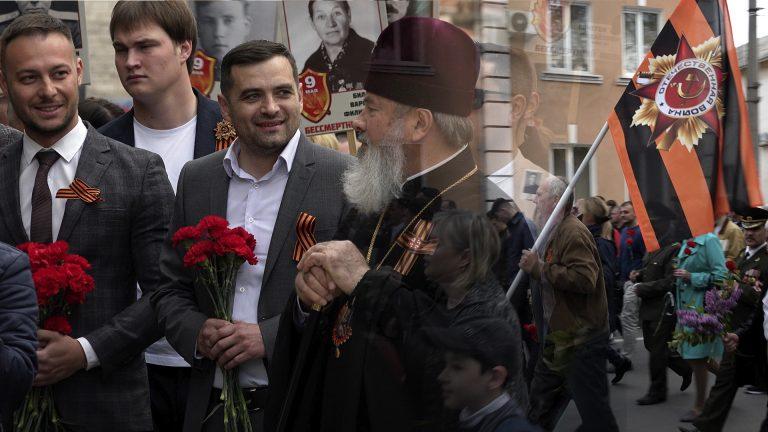 /VIDEO/ Sfidează legea fără ca să-i mustre consțiința. Episcopul Marchel a purtat la parada de 9 mai panglica interzisă și a bruscat