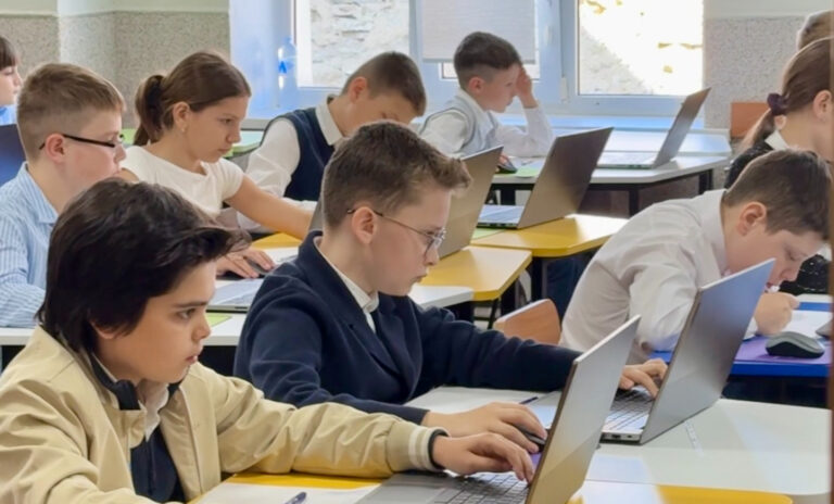 Elev de clasa a IV-a susține testarea digitală la matematică într-o sală dotată cu computere