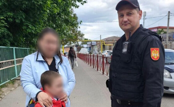 Angajat IGC alături de un copil salvat, în fața unei stații peco din Bălți