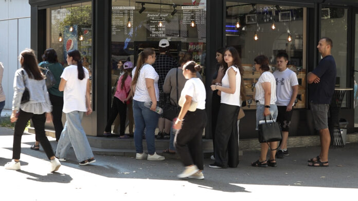 Locuitori din Bălți aleg între fast-food și mâncare sănătoasă, pe fundalul unui stand cu pizza și shaorma