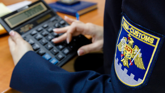 Vameș verificând documente la punctul de trecere Leușeni, unul dintre cele mai aglomerate posturi vamale din Moldova.