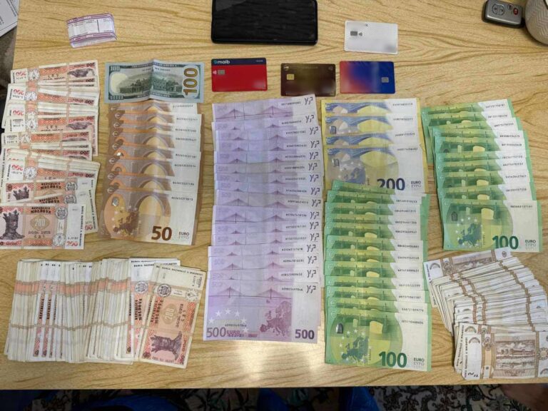 Ofițerii CNA ridică probe în timpul perchezițiilor într-un dosar de finanțare ilegală a partidelor politice.
