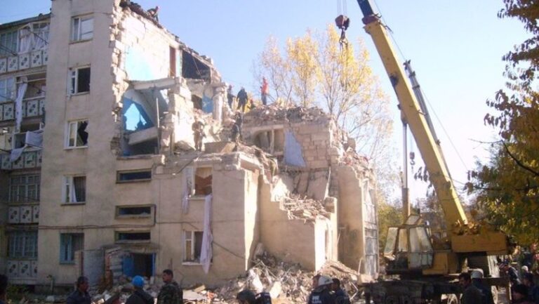 Oamenii depun flori la placa comemorativă ridicată pe locul blocului distrus în explozia din Soroca din 2007.