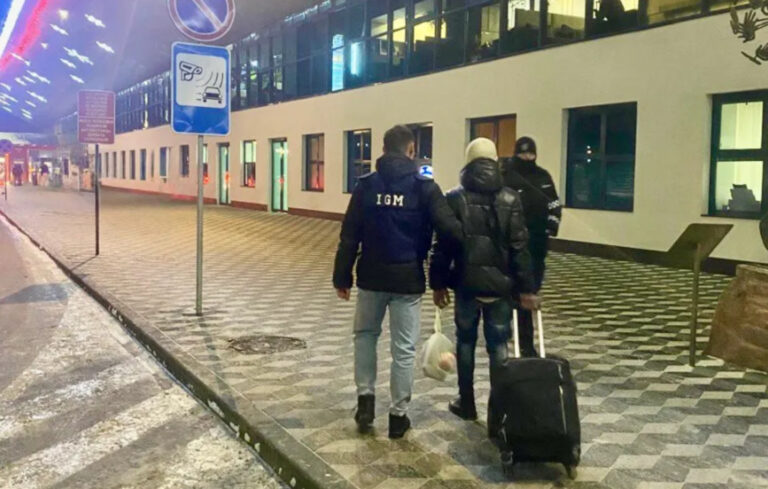 Ofițeri ai Inspectoratului General pentru Migrație în timpul îndepărtării sub escortă a unui cetățean străin.